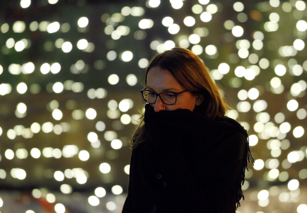 A woman covers her face during a period of fog and air pollution in Skopje, Macedonia December 4, 2018. REUTERS/Ognen Teofilovski