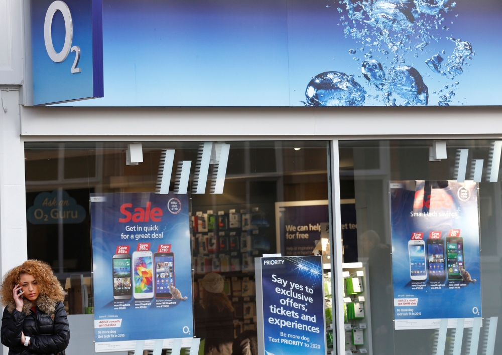 FILE PHOTO: A woman speaks on her mobile telephone outside an O2 shop in Loughborough, central England January 23, 2015. REUTERS/Darren Staples