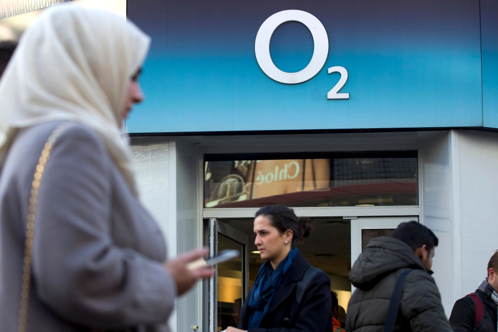 In this file photo taken on January 23, 2015 People walk past a branch of an O2 store in central London on Janurary 23, 2015.  / AFP / Justin TALLIS 
