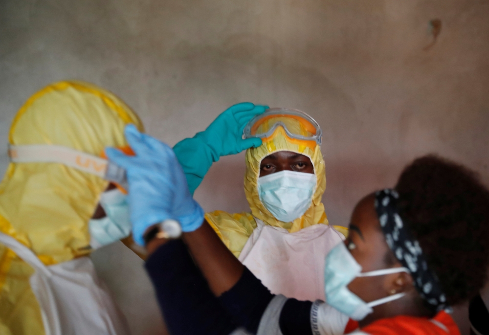 Healthcare workers adjust gear during a funeral of Kavugho Cindi Dorcas who is suspected of dying of Ebola in Beni, North Kivu Province of Democratic Republic of Congo, December 9, 2018. REUTERS/Goran Tomasevic
