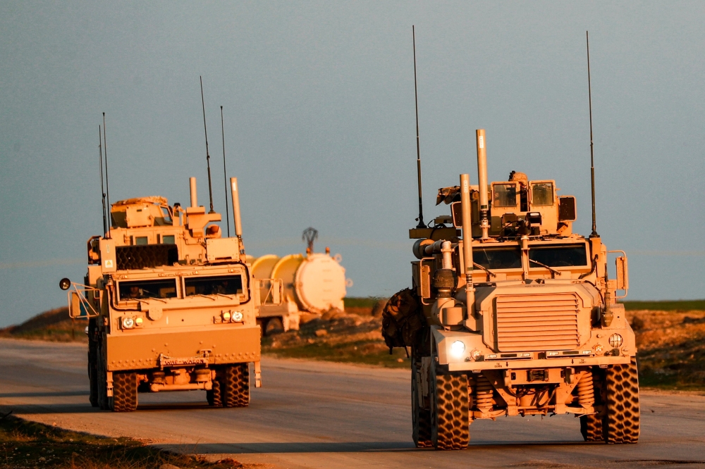 US Marine Corps tactical vehicles are seen driving along a road near the town of Tal Baydar in the countryside of Syria's northeastern Hasakeh province on December 21, 2018.  AFP / Delil SOULEIMAN