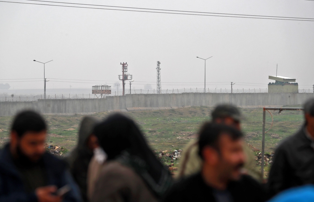 Turkish observation posts are seen on the Turkish side as Kurdish protesters gather to protest near the border wall separating Turkey from Syria in the western Syrian countryside of Ras al-Ain on December 20, 2018. AFP / Delil Souleiman