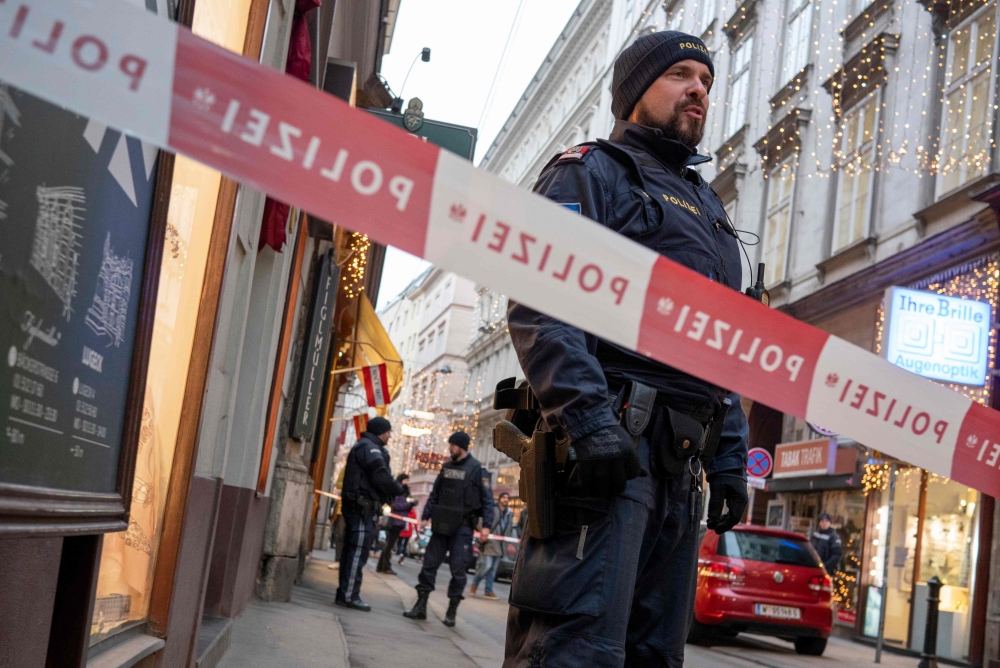Austrian policemen stand guard at the site of a shooting outside Figlmueller passage in the city center of Vienna, Austria, on December 21, 2018. AFP / JOE KLAMAR
