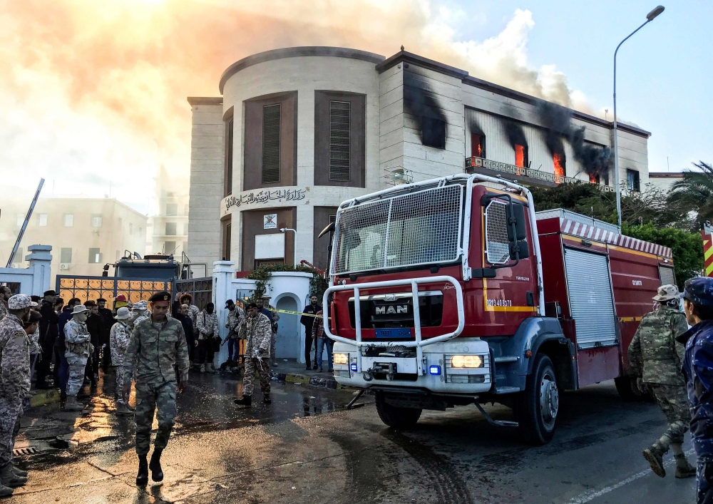  A picture taken on December 25, 2018 shows a firetruck and security officers at the scene of an attack outside the Libyan foreign ministry headquarters in the capital Tripoli. AFP / Mahmud TURKIA