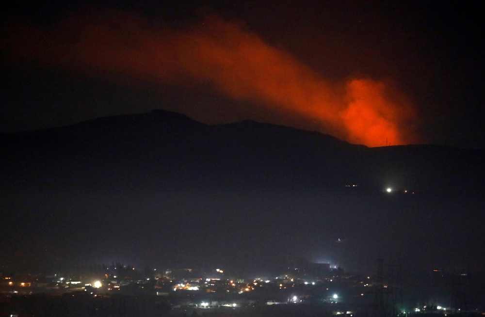 Smoke rises past a mountain as seen from Damascus countryside, Syria December 25, 2018. REUTERS/Omar Sanadiki