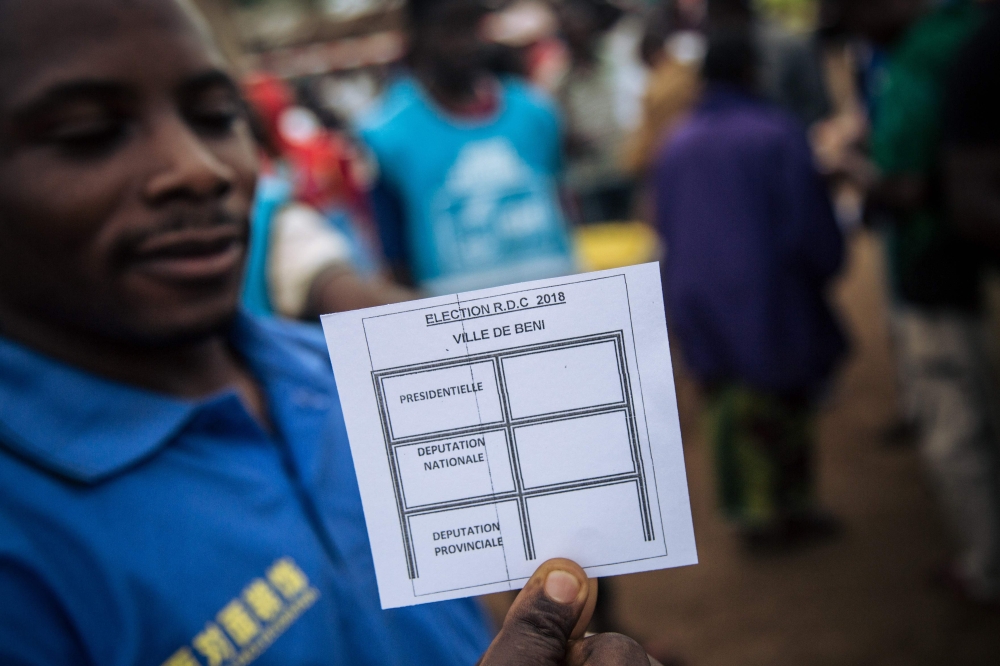 A man shows a ballot paper in an improvised polling station in the streets of a district in Beni, on December 30, 2018. AFP / ALEXIS HUGUET