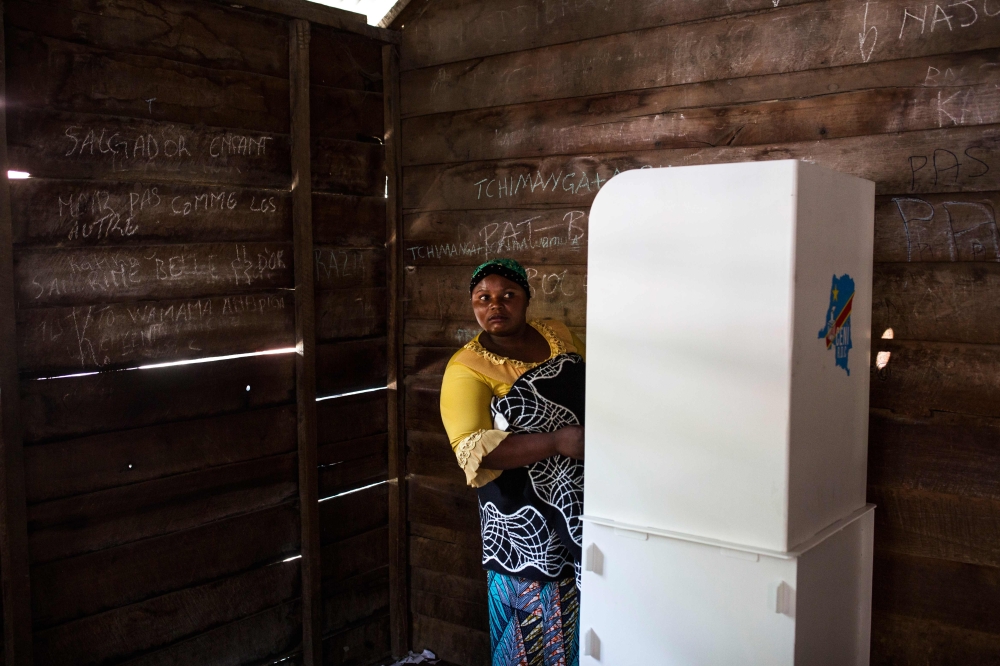 A woman in a polling booth asks for help while casting her ballot at the Matcha polling station in Sake, North Kivu, on December 30, 2018.  AFP / PATRICK MEINHARDT