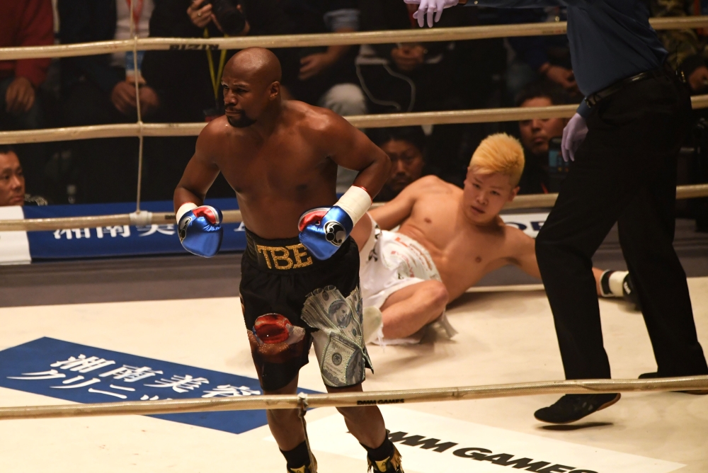 US boxing legend Floyd Mayweather Jr (L) knocks down Kickboxer Tenshin Nasukawa of Japan (C) during their exhibition match at Saitama Super Arena in Saitama on December 31, 2018. (AFP / Toshifumi KITAMURA)