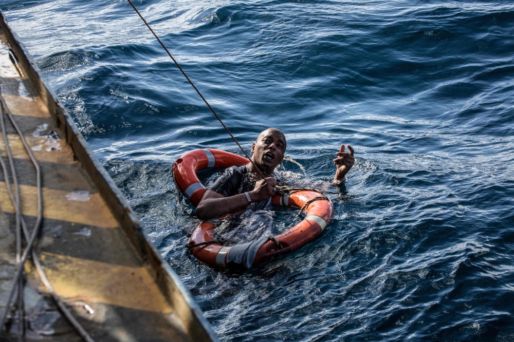 A migrant is being rescued on January 4, 2019 with buoys and a rope, after he dived in the cold Mediterranean off Malta's coast from the Dutch-flagged Sea-Watch 3 rescue vessel, in a attempt to reach the shore by swimming. The Sea-Watch 3, a Dutch-flagged