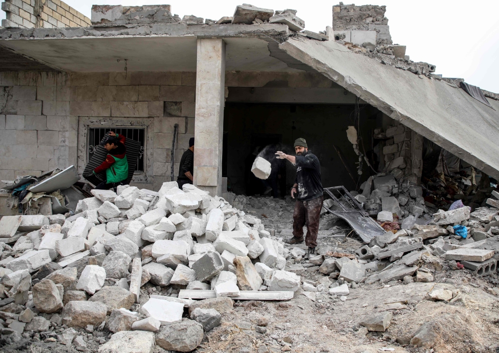 A Syrian man clears debris from a building that was damaged by a reported air strike in the rebel-held town of Orum al-Kubra, in the northern Syrian province of Aleppo, on January 5, 2019.   AFP / Aaref WATAD
