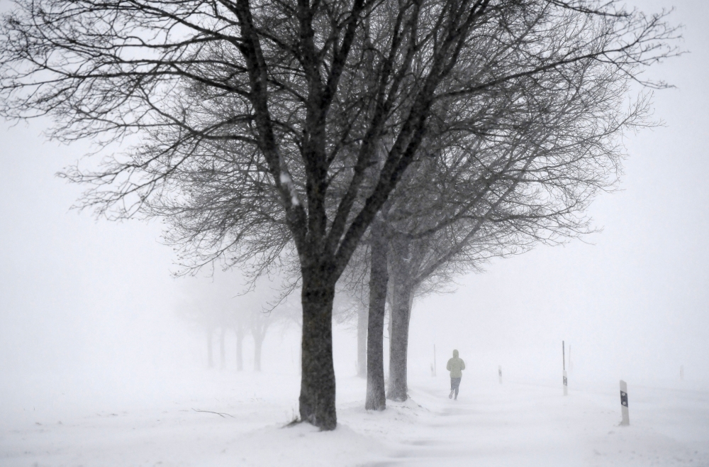 A jogger runs during winter weather in Seeon, Germany, January 5, 2019. REUTERS/Andreas Gebert