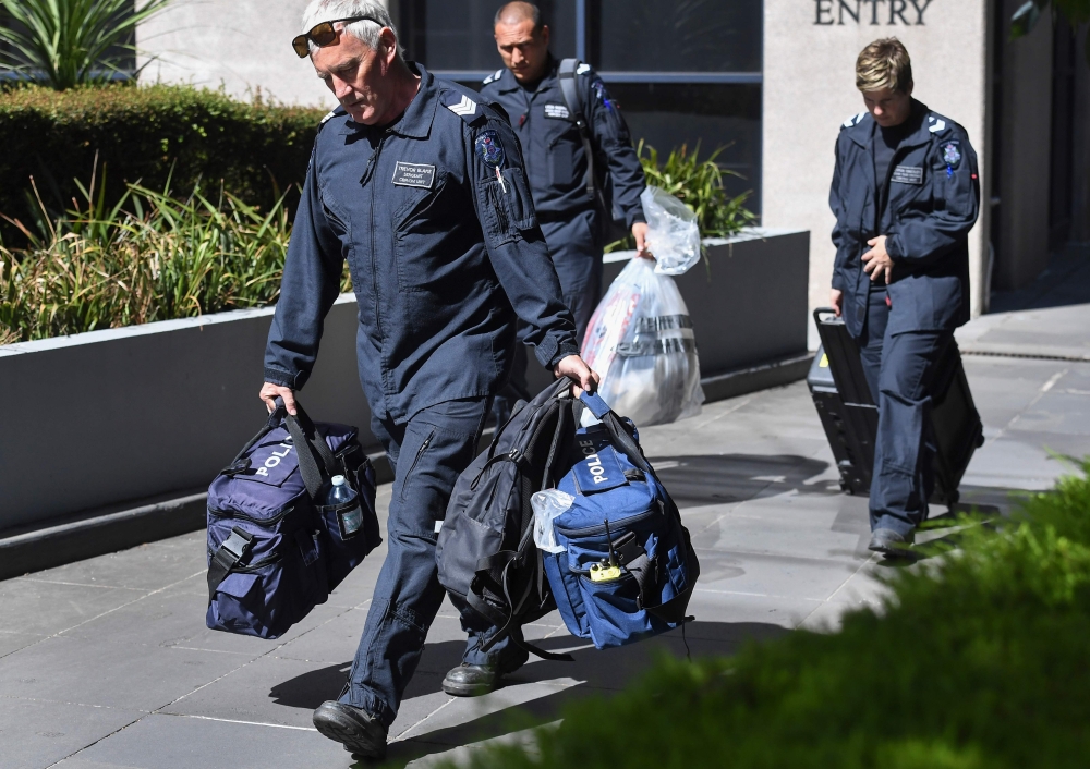 Victoria Police forensic officers remove a bag from the Italian consulate in Melbourne on January 9, 2019. / AFP / William WEST 