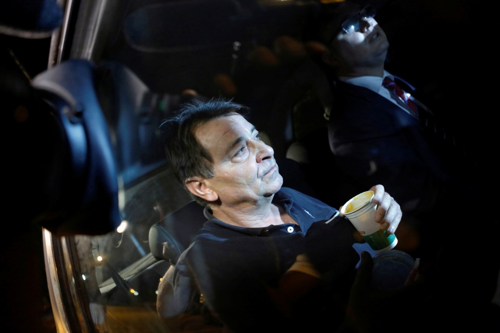 FILE PHOTO: Italian former leftist guerrilla Cesare Battisti sits in a taxi next to his lawyer Igor Tamasauskas as they leave the headquarters of the Federal Police in Sao Paulo March 13, 2015. REUTERS/Nacho Doce/File photo