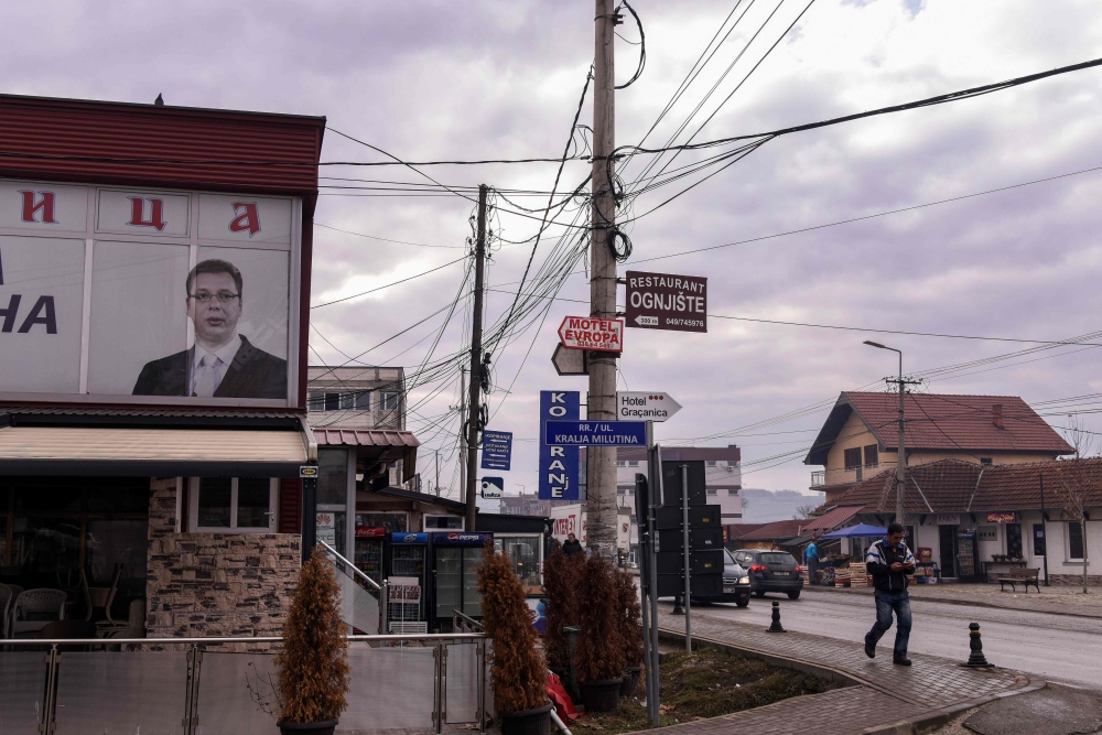 A man walks next to the portrait of the Serbian President displayed at the office of a Serbian political party in the town of Gracanica near Pristina, on December 29, 2018. AFP / Armend Nimani 