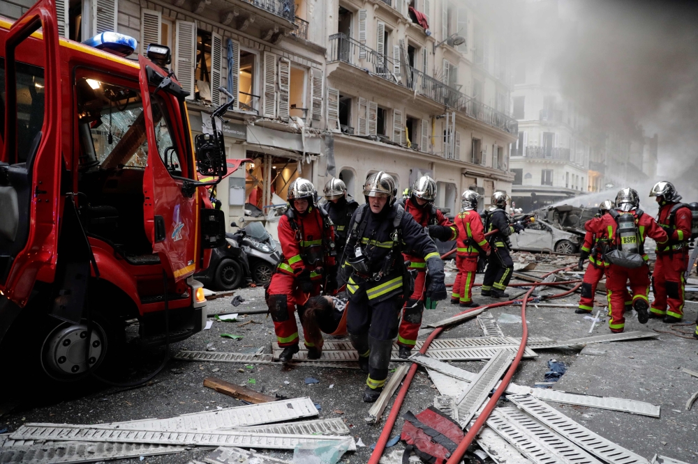 Firefighters evacuate an injured person on a stretcher after the explosion of a bakery on the corner of the streets Saint-Cecile and Rue de Trevise in central Paris on January 12, 2019. AFP / Thomas Samson 