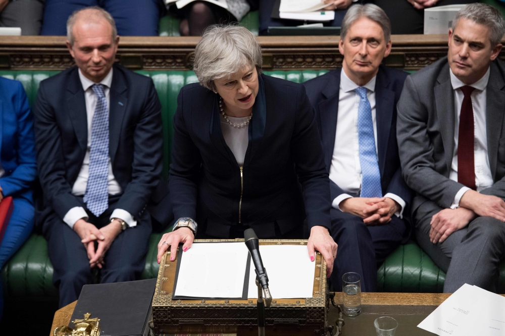 A handout photograph released by the UK Parliament shows Britain's Prime Minister Theresa May (C) making a statement in the House of Commons in London on January 15, 2019 directly after MPs rejected the government's Brexit deal. AFP/ Jessica Taylor / UK P