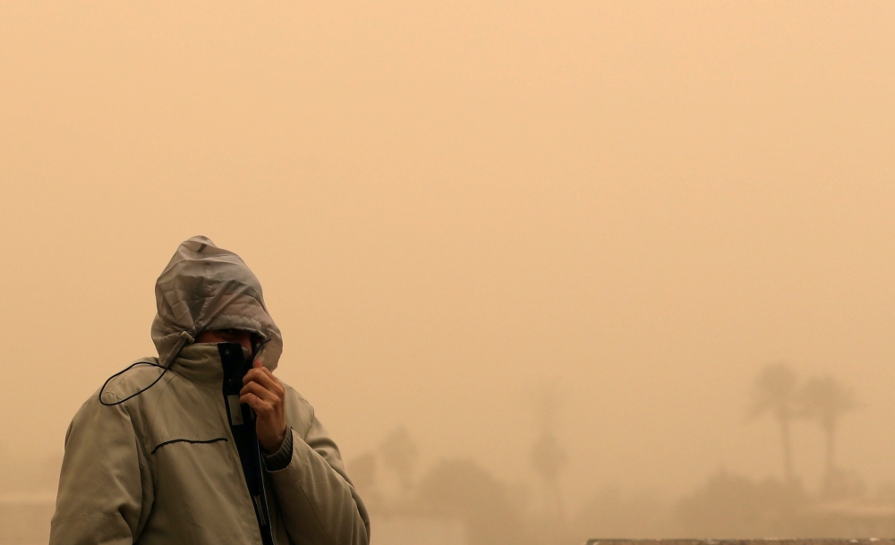 A man covers his face during a sandstorm in Cairo, Egypt January 16, 2019. Mohamed Abd El Ghany \ REUTERS .