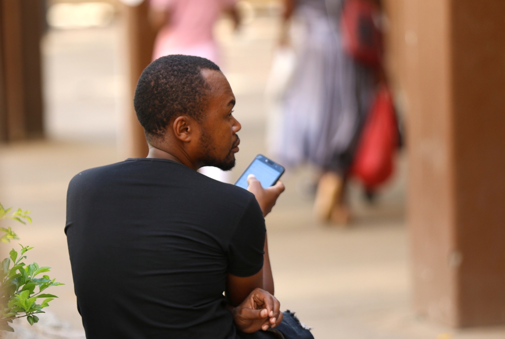 A man checks his mobile phone in Harare, Zimbabwe, January 18, 2019. Reuters/Philimon Bulawayo
 