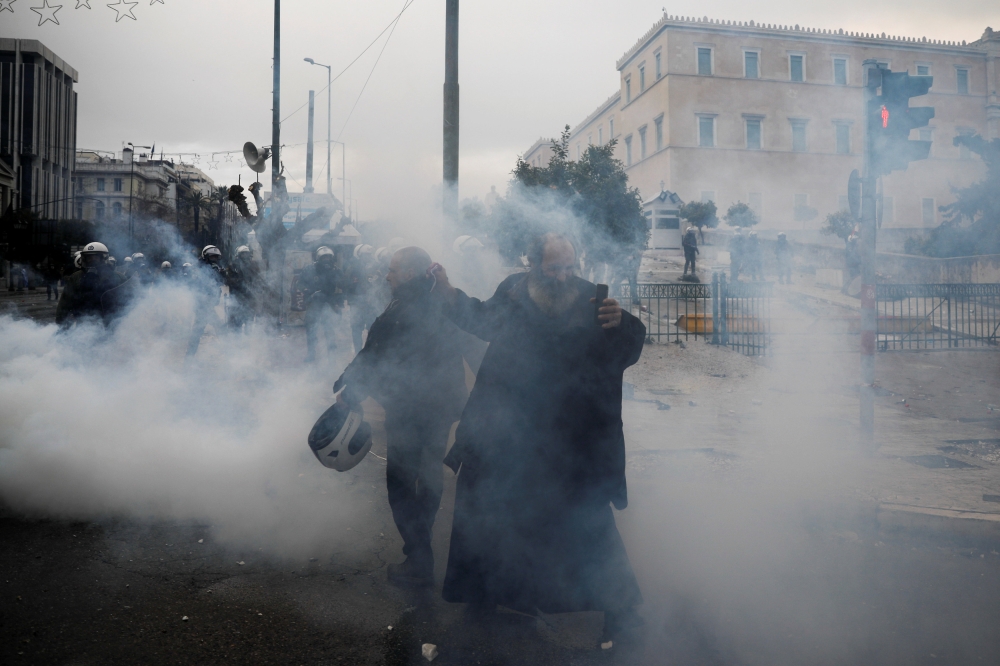 A priest reacts next to police officers during a demonstration against the agreement reached by Greece and Macedonia to resolve a dispute over the former Yugoslav republic's name, in Athens, Greece, January 20, 2019. Reuters/Alkis Konstantinidis 