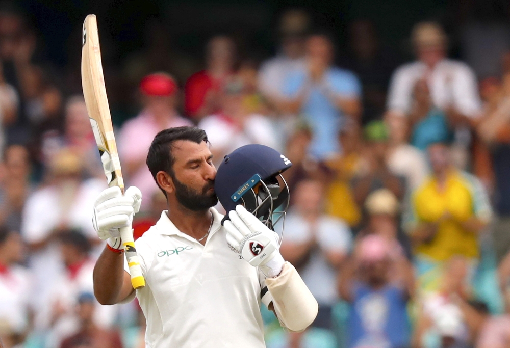 (FILES) In this file photo taken on January 3, 2019, India's Cheteshwar Pujara kisses his helmet after reaching his century (100 runs) during the first day of the fourth and final cricket Test against Australia at the Sydney Cricket Ground in Sydney. AFP 