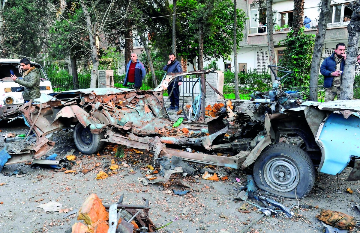  Aandout picture released by the official Syrian Arab News Agency (SANA) on January 24, 2019 shows people looking at the remains of a car which exploded following a bomb attack near the Russian embassy in the Syrian capital Damascus. Via AFP