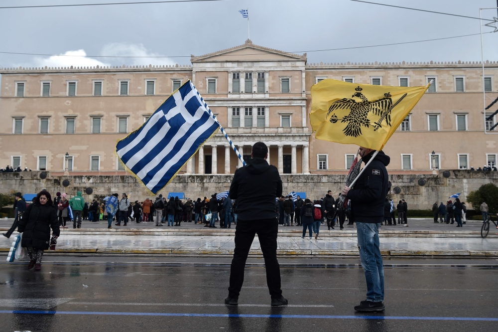 Protesters stand in front of the Greek Parliament in Athens on January 25, 2019.  AFP / Louisa Gouliamaki 