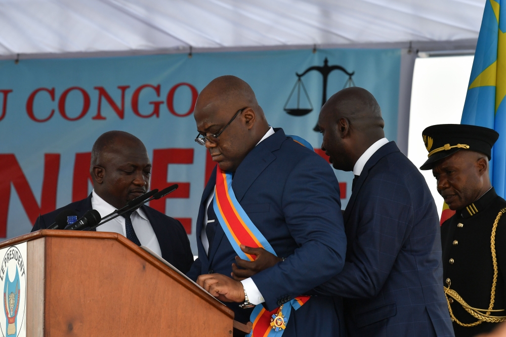 Democratic Republic of the Congo's newly inaugurated President Felix Tshisekedi is assisted by an aide on January 24, 2019 after he fell ill while delivering his official speech that followed his inauguration at the Presidency in Kinshasa.   AFP / TONY KA