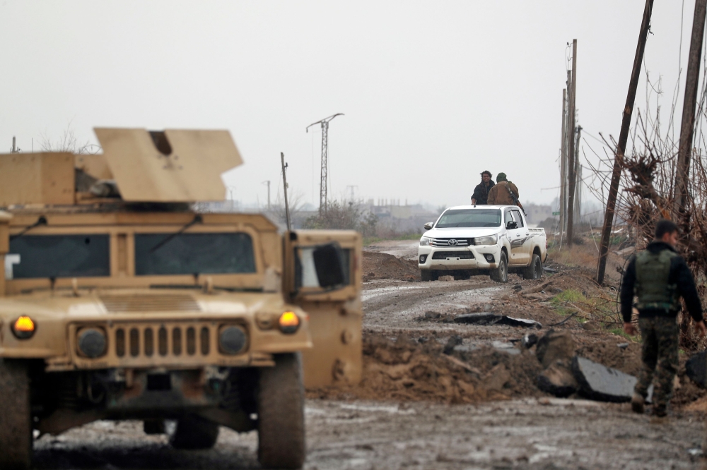 A picture taken on January 27, 2019 in the Syrian village of al-Susah in the countryside of Syria's eastern Deir Ezzor province, near the border with Iraq, shows fighters from the Kurdish-led Syrian Democratic Forces (SDF) heading to the frontline with th