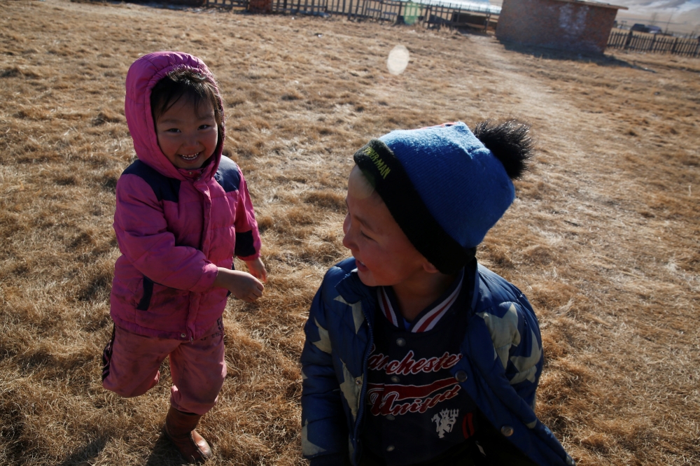 Ukhaanzaya Gankhuyag, 5, and Namuun (R), 5, play outside their Mongolian ger in Tov province outside Ulaanbaatar, Mongolia January 30, 2019. Picture taken January 30, 2019. REUTERS/B. Rentsendorj