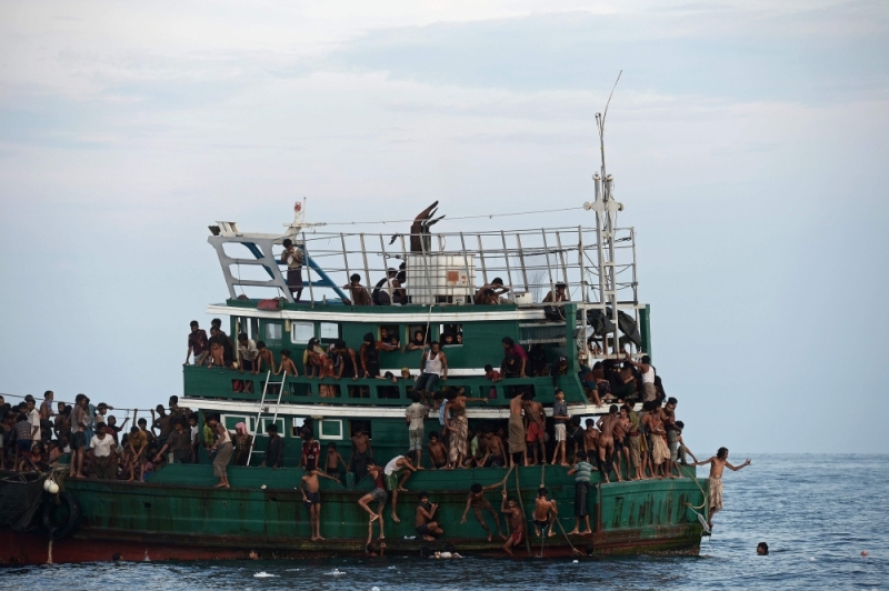 Rohingya migrants bring back food supplies dropped by a Thai army helicopter from sea a boat drifting in Thai waters off the Koh Lipe island in the Andaman sea, May 14, 2015. AFP/Christophe Archambault