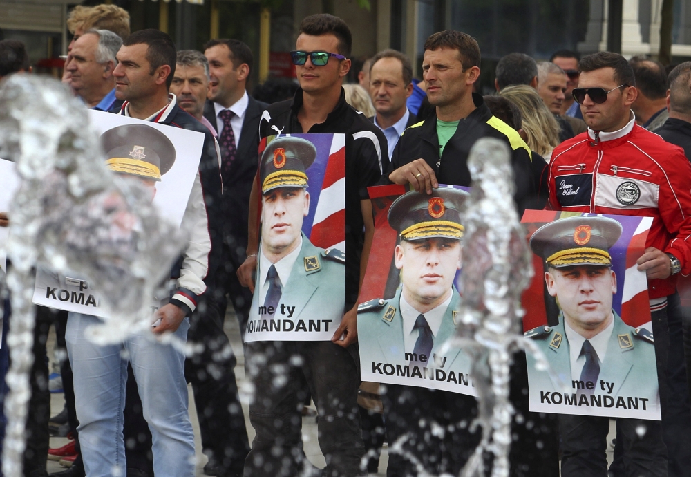 Protesters hold posters of Sylejman Selimi, a war commander during the 1998-1999 war, during a protest against a parliamentary vote to create a new war crimes court in Pristina, Kosovo May 29, 2015. Reuters/Hazir Reka