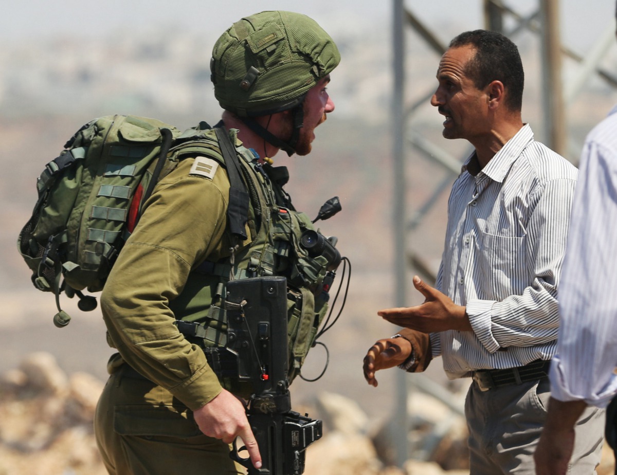 A Palestinian argues with an Israeli soldier during clashes near the West Bank village of Qusra, west of Nablus, August 9, 2016. Reuters/Mohamad Torokman