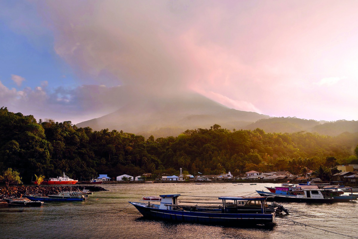 This picture taken at Pehe port on Siau island, Indonesia's North Sulawesi province shows Karangetang volcano spewing smoke on February 7, 2019.  AFP / Ungke Pepotoh
