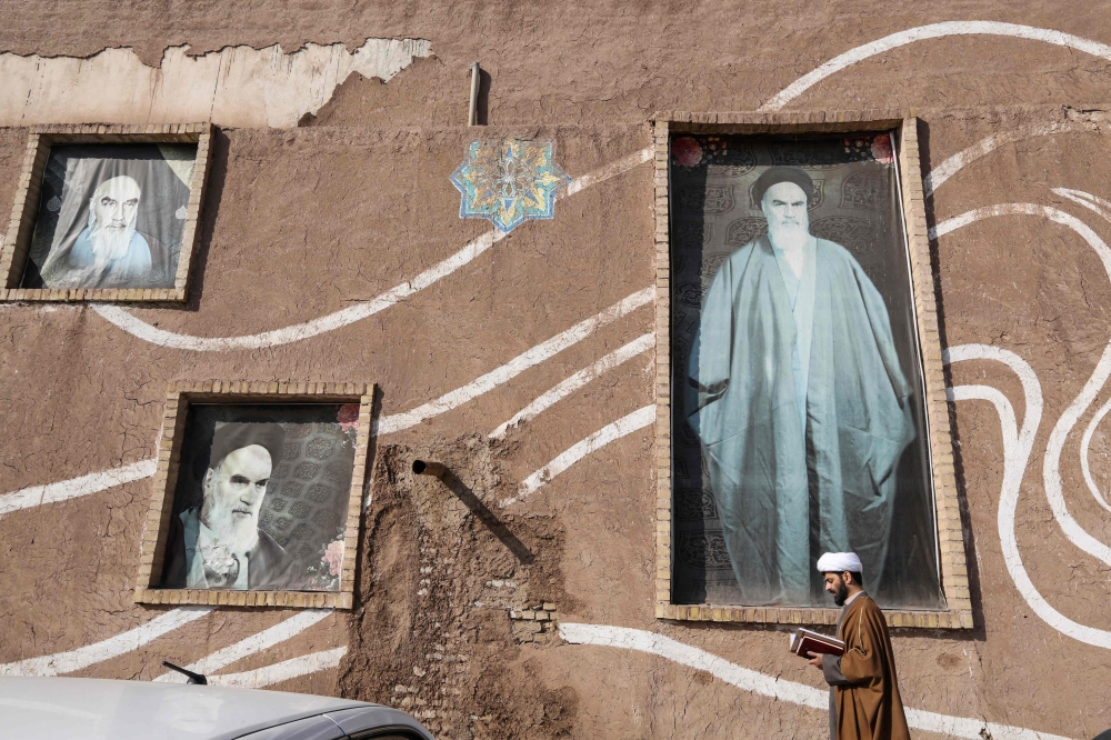 A Muslim Shiite cleric walks past the house of the late founder of the Islamic Republic, Ayatollah Ruhollah Khomeini, in the holy city of Qom, 130 kilometres south of Tehran on January 15, 2019.  / AFP / ATTA KENARE 