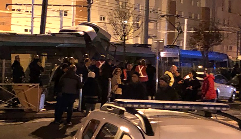 Emergency personnel and bystanders gather at the scene of a collision between two trams at Issy-les-Moulineaux, south-west of Paris on February 11, 2019. AFP / Philippe Dupeyrat 