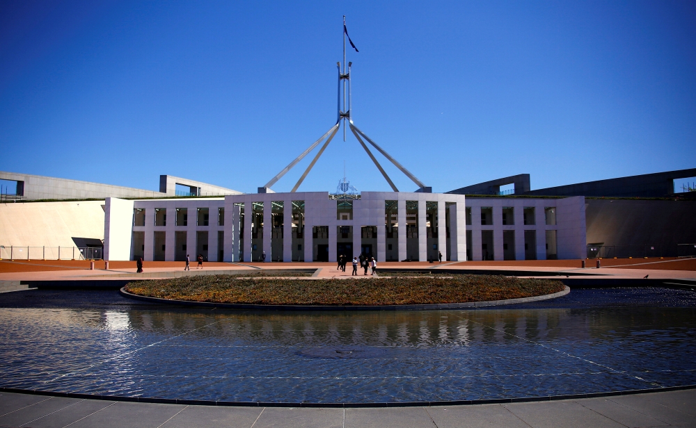 FILE PHOTO - Tourists walk around the forecourt of Australia's Parliament House in Canberra, Australia, October 16, 2017. REUTERS/David Gray/File Photo	