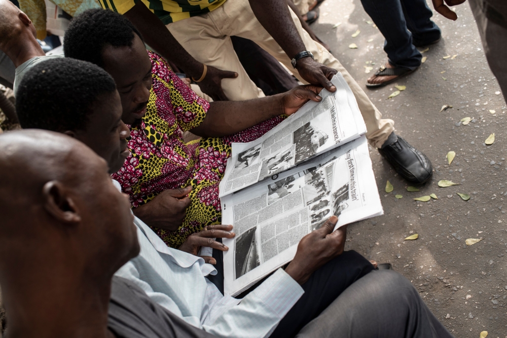 Nigerians read a daily newspaper on February 16, 2016 in Lagos after the national election has been postponed.   AFP / STEFAN HEUNIS