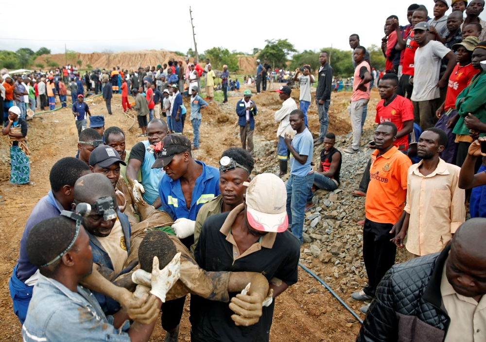 A rescued artisanal miner is carried from a pit as retrieval efforts proceed for trapped illegal gold miners in Kadoma, Zimbabwe, February 16, 2019. REUTERS/Philimon Bulawayo