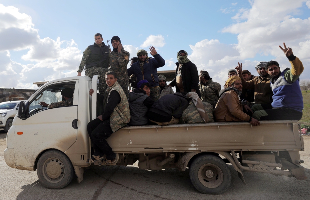 Members of Syrian Democratic Forces (SDF) gesture as they ride a truck in the village of Baghouz, Deir Al Zor province, Syria February 17, 2019. REUTERS/Rodi Said