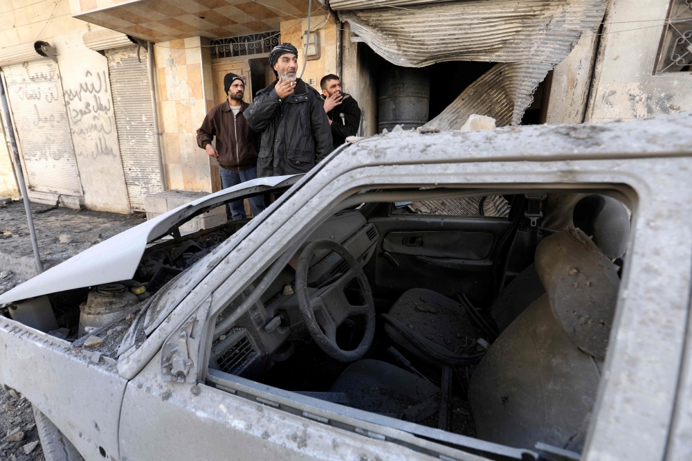 Syrian men look at the destroyed house of their neighbour in the rebel-held town of Maaret al-Numan in the north of Idlib province on February 18, 2019, following reported shelling by government forces. / AFP / OMAR HAJ KADOUR
