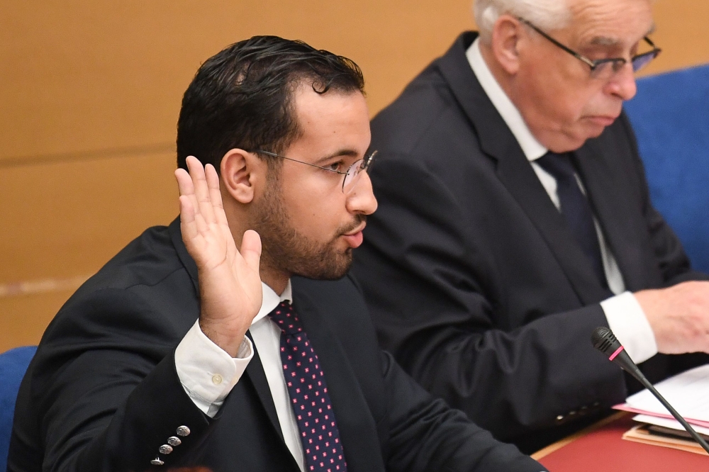 In this file photo taken on September 19, 2018, Former Elysee senior security officer Alexandre Benalla raises his hand as he takes the oath before a Senate committee in Paris. AFP/Alain Jocard