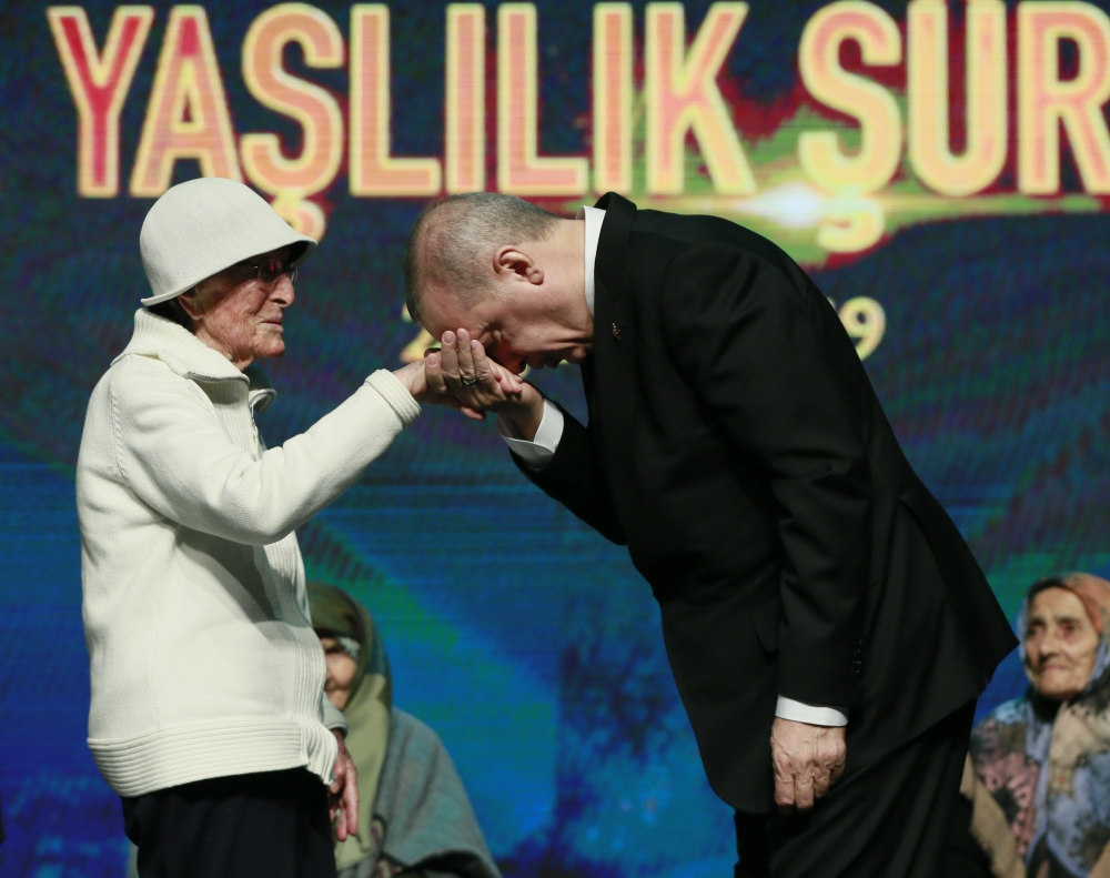 President of Turkey, Recep Tayyip Erdogan (R) kisses an elderly's hand during the 