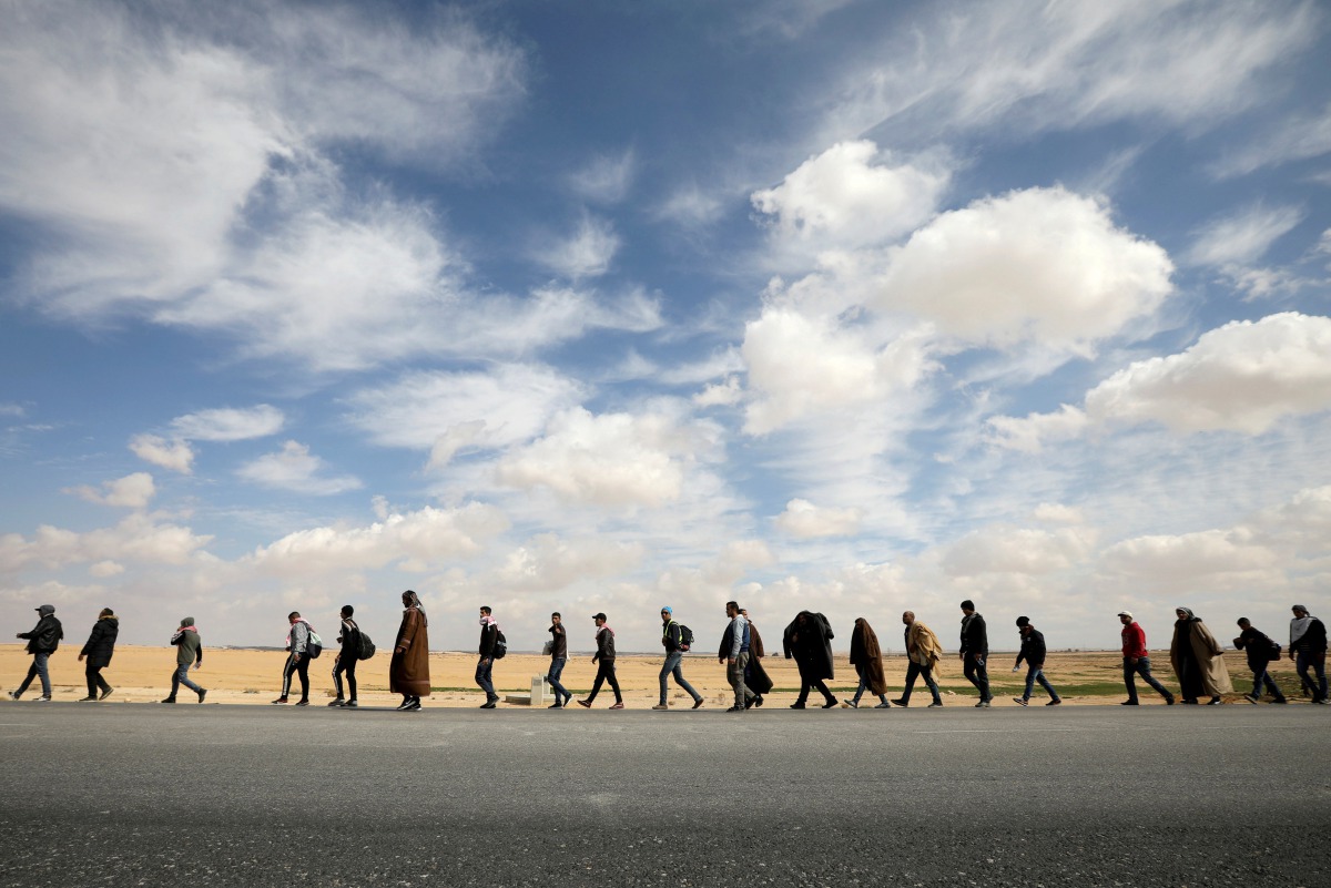 People walk during a march from the city of Aqaba south of the capital, demanding more employment opportunities, on the highway near Amman, Jordan, February 20, 2019. Reuters/Muhammad Hamed 