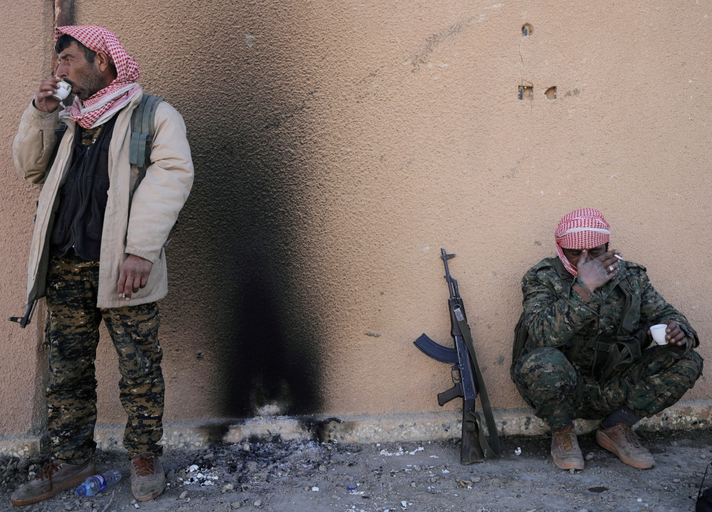 FILE PHOTO: Fighters from the Syrian Democratic Forces (SDF) drink tea in the village of Baghouz, Deir Al Zor province, Syria February 18, 2019. REUTERS/Rodi Said