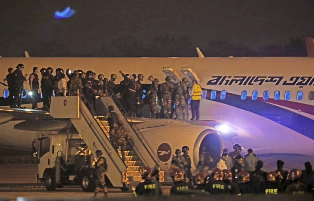 Bangladeshi security personnel stand guard near a Dubai-bound Bangladesh Biman plane on the tarmac of the Shah Amanat International Airport in Chittagong on February 24, 2019, following an emergency landing after a man apparently attempted to hijack the a