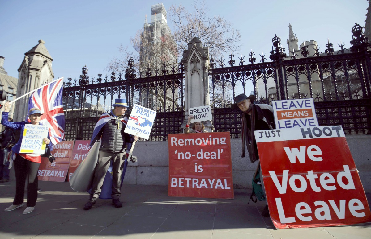 Anti-Brexit activists (L) and pro-Brexit activists demonstrate outside of the Houses of Parliament in London on February 25, 2019.  AFP / Tolga Akmen
