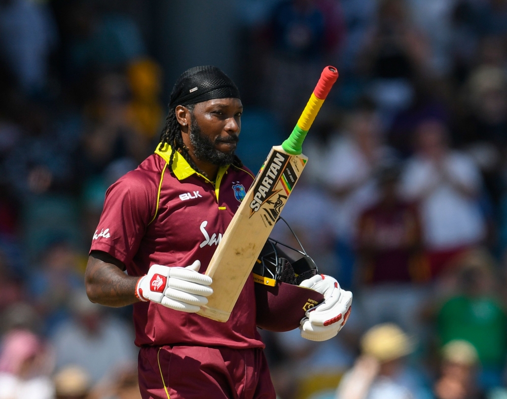 Chris Gayle (R) of West Indies celebrates his century during the 1st ODI between West Indies and England at Kensington Oval, Bridgetown, Barbados, on February 20, 2019. / AFP / Randy Brooks
