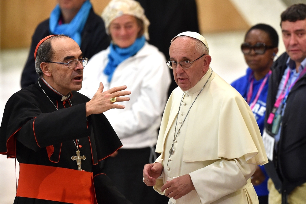 Pope Francis (R) listens to French Cardinal Philippe Barbarin (L) during an audience with homeless and socially excluded people in the Paul-VI hall at the Vatican on November 11, 2016. AFP / Alberto Pizzoli