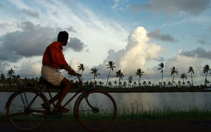 A man rides a bicycle against the backdrop of monsoon clouds on the outskirts of Kochi in this Reuters file photo. Kerala, which suffered its worst floods in a century last year, is bracing itself for more extreme weather conditions in 2019 and the state'
