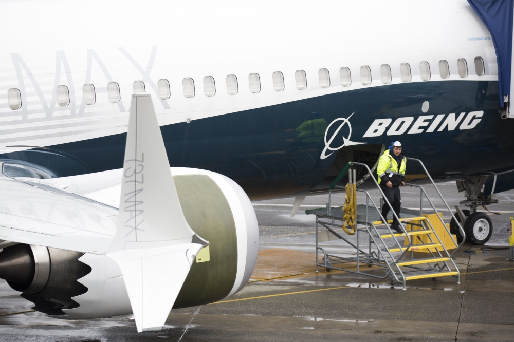 A worker is pictured next to a Boeing 737 MAX 9 airplane on the tarmac at the Boeing Renton Factory in Renton, Washington on March 12, 2019. AFP / Jason Redmond